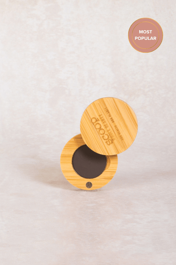 small round swivel compact filled with a brown brow wax - light - maca - walnut - medium - tan