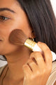 Scoop Whole Beauty ultra soft vegan kabuki brush used by model to apply natural mineral sun-kissed bronzer. 