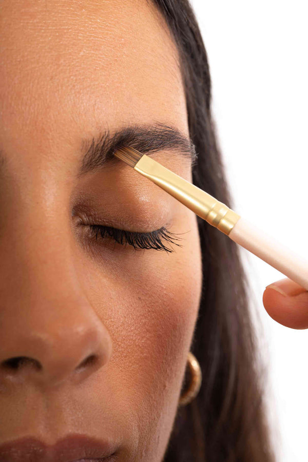 Scoop Whole Beauty model applies natural brow balm to eyebrows using vegan brush