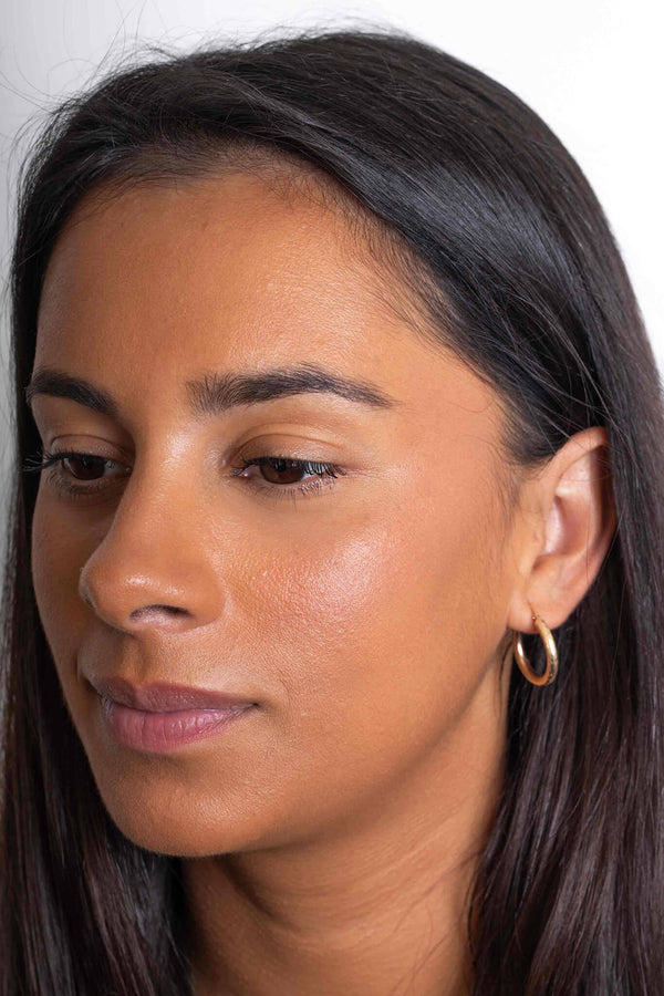 Scoop Whole Beauty model wears natural liquid cover mineral foundation in shade tan displaying its hydrating and glowing effect- tan