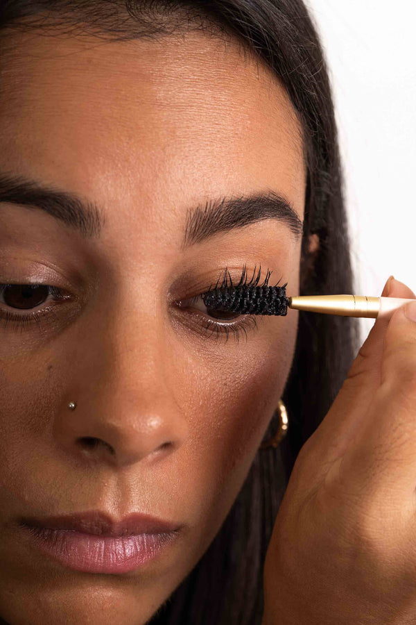 Scoop Whole Beauty model applies the eco friendly, natural, non toxic mud cake mascara to eyelashes - midnight black