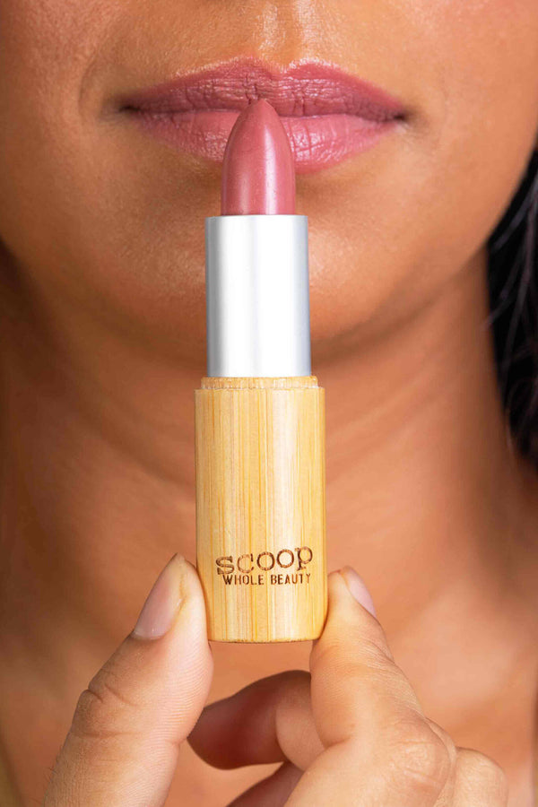 Scoop Whole Beauty model wears natural lipstick in sustainable bamboo tube in shade rose. Ultra hydrating and long lasting