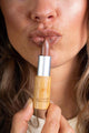 Scoop Whole Beauty model wears natural lipstick in sustainable bamboo tube- nude