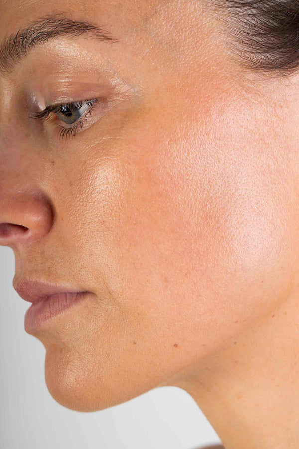 image of woman wearing the Scoop Whole Beauty Full-Loop Pure Mineral Powder Foundation on skin with close up of her cheek - walnut