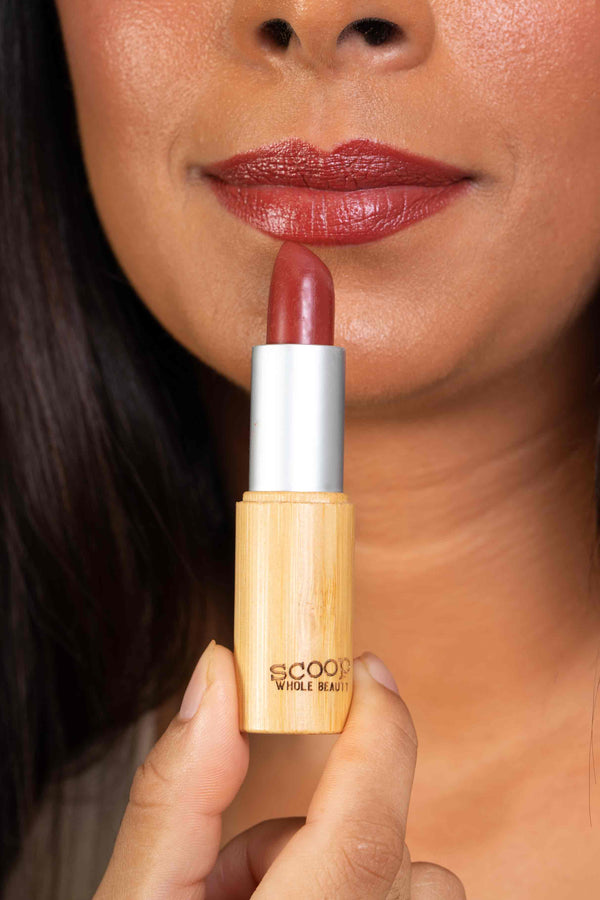 lipstick held up to the lips to show the shade on the lips verses in the tube - maca - medium - tan - cocoa