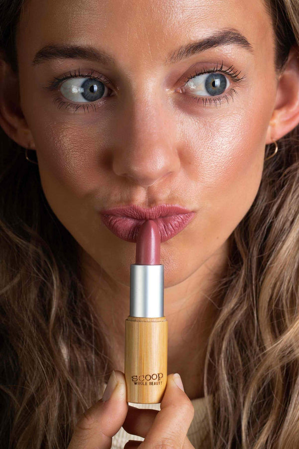 Scoop Whole Beauty model applies natural lipstick in sustainable bamboo tube -rose
