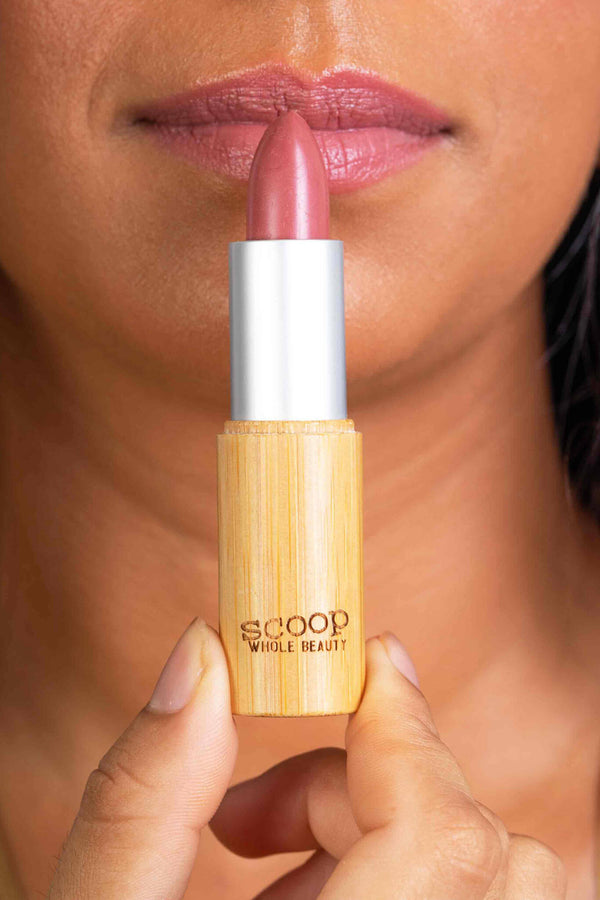Scoop Whole Beauty model applies natural lipstick in sustainable bamboo tube -rose