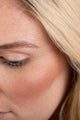 Scoop Whole Beauty model wearing natural mineral highlighter, blusher, bronzer and non-toxic mud cake mascara - highlight