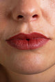 Scoop Whole Beauty model wears natural lipstick in sustainable bamboo tube -cherry