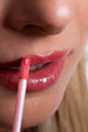 Scoop Whole Beauty model applies natural, non toxic lipgloss - pink pitaya
