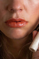 Scoop Whole Beauty model wears natural lipstick with a top coat of clear lipgloss- peach