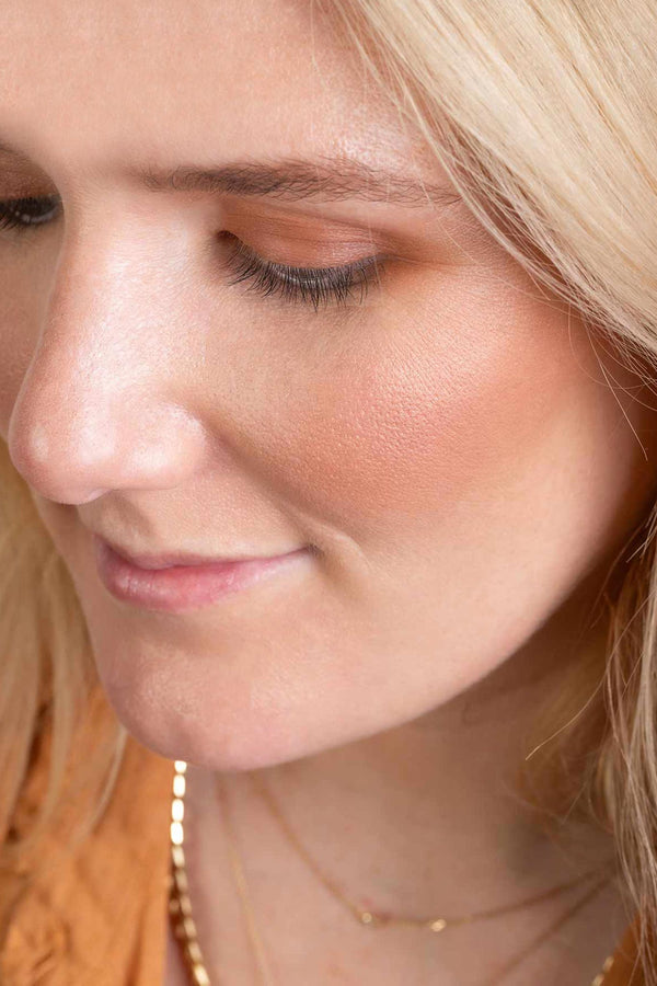  Scoop Whole Beauty model, Emily, showcases bronzed look wearing herbal primer, pure mineral powder foundation with SPF, natural mineral bronzer, dusty pink blusher, terracotta eyeshadow and brow balm 