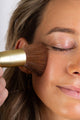 Scoop Whole Beauty model applying liquid mineral cover with our vegan foundation brush  