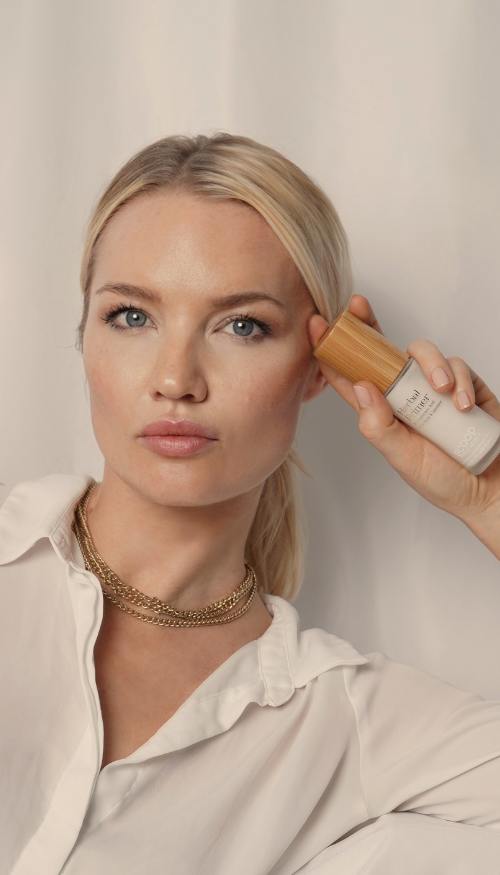 a woman holding the scoop whole beauty herbal primer