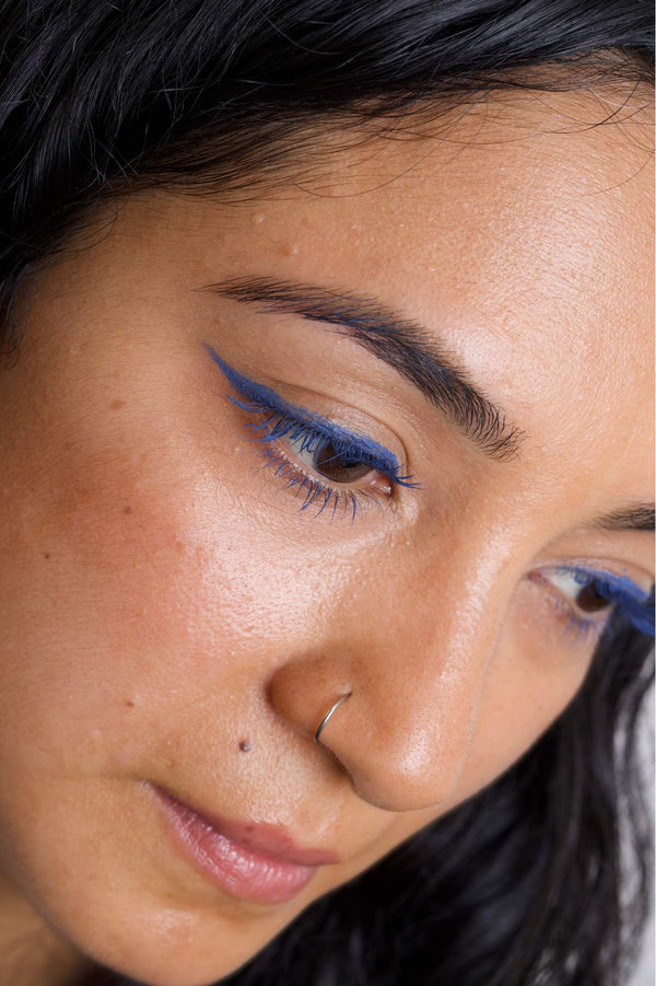 Scoop whole beauty model is wearing the mud cake mascara in the shade ocean blue applied as an eyeliner, mascara and on the eyebrows.
