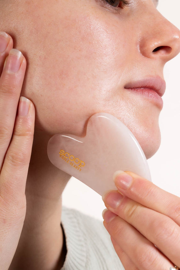 Scoop Whole Beauty model massages face with organic, cold pressed, Australian, jojoba oil and rose quartz gua sha