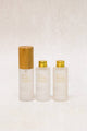 three glass bottles, one with a bamboo lid and the other two with gold aluminium caps. frosted glass with gold text. All containing Natural Hyaluronic Acid Serum 2% + B3 from Scoop Whole Beauty.