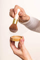 brush picking up powder from the lid of the foundation jar - light - maca - walnut - medium - tan