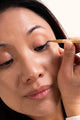 Scoop Whole Beauty model applies the eco friendly, natural, non toxic mud cake mascara to eye lid as eye liner
