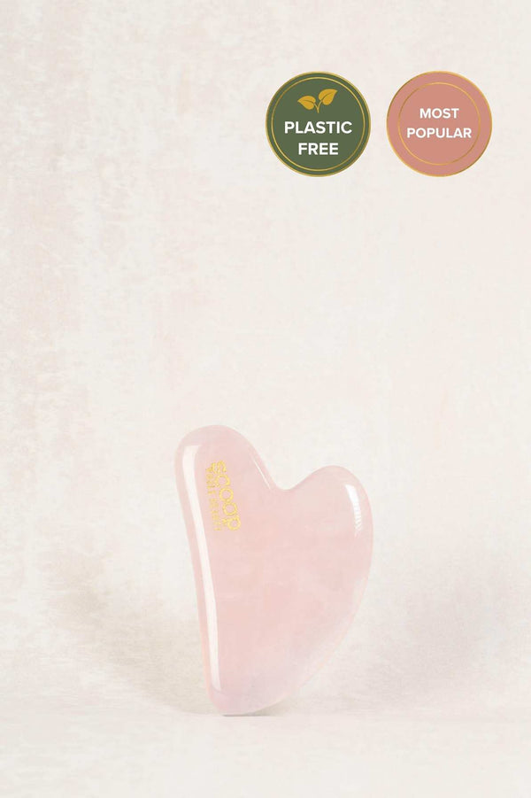 heart shaped pink stone used for facial massage with gold scoop whole beauty logo.
