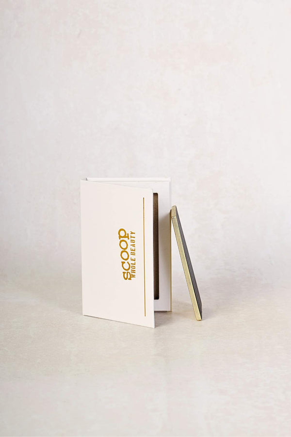 empty mud cake mascara refill box with the refill plate standing upwards alongside it and leaning against it - midnight black