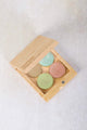 Scoop Whole Beauty's Coral Reef Eyeshadow Palette in its open bamboo compact showing the 4 eyeshadow shades in a gold colored pan.
