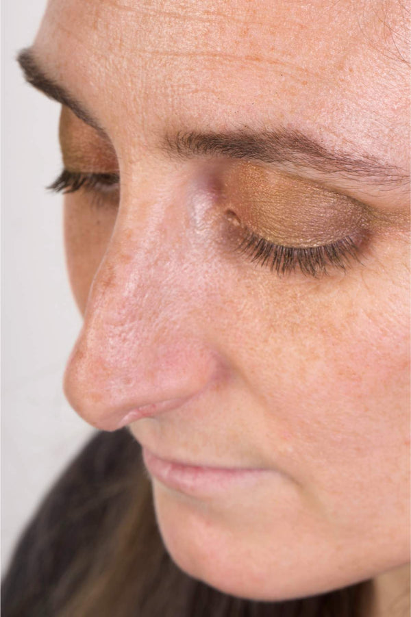 The model is looking down, showing the eyeshadow shade siren in her eyelids.