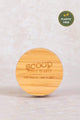 Plastic-free round bamboo compact by Scoop Whole Beauty, featuring eco-friendly, sustainable packaging engraved with the brand’s motto 'Our Health – Our Planet'.